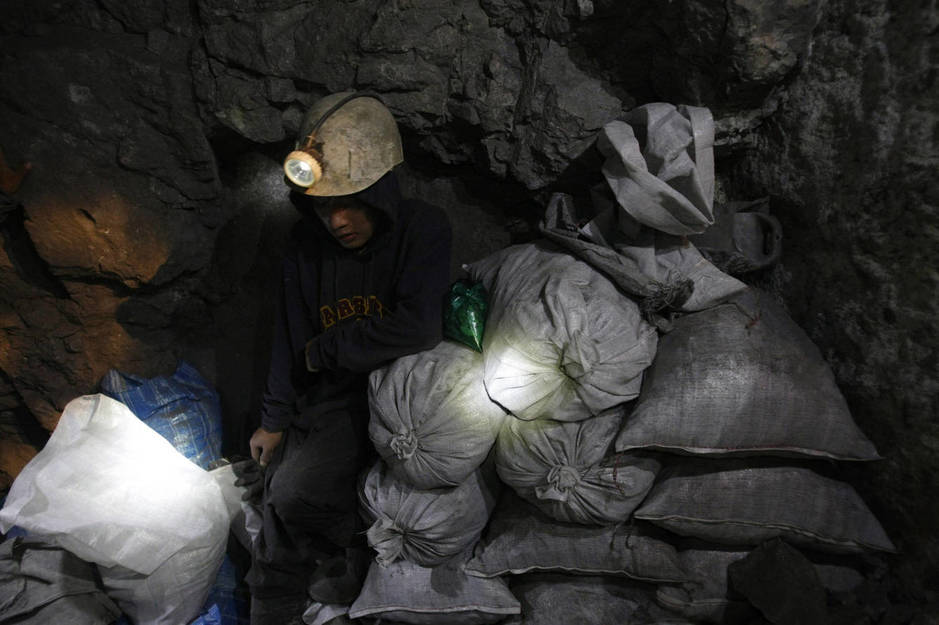 Moisés, un joven minero de 17 años, guarda sacas de mineral en la mina de El Rosario en Cerro Rico, en enero de 2010. (Reuters)