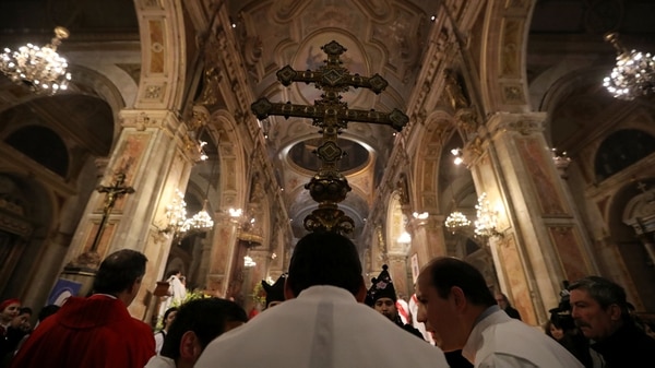 Los miembros de la iglesia sostienen una cruz durante una misa en la catedral de Santiago el 25 de julio de 2018 (Reuters)