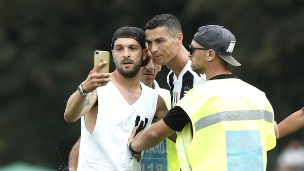 Cristiano posó para la foto con el fanático que saltó al campo (Foto: AFP)