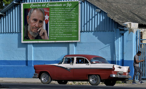 Un viejo automóvil junto a un cartel del difunto líder cubano Fidel Castro en La Habana. Foto: AFP