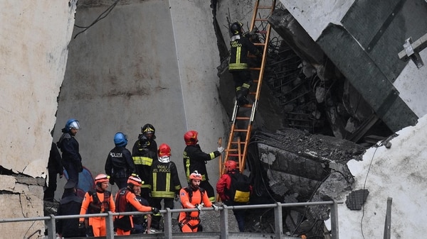 Miembros de los servicios de emergencia buscan entre los escombros tras derrumbarse una sección del viaducto Morandi en Génova (EFE)