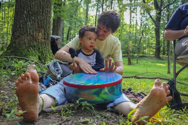 Kristina Byrne toca el tambor junto a su hijo Adisa Jones, de 2 años en uno de los servicios religiosos de la “Iglesia de la Selva” (The Washington Post / Dayna Smith)