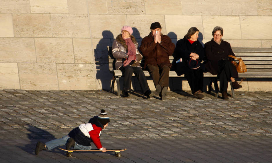 Varios pensionistas observan a un niño con un monopatín, en Berlín. (Reuters)