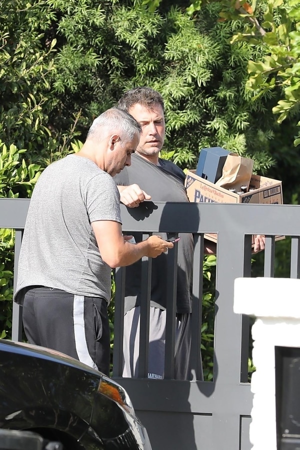Ben Affleck en su casa de Los Ángeles recibiendo las botellas de alcohol (Grosby Group)