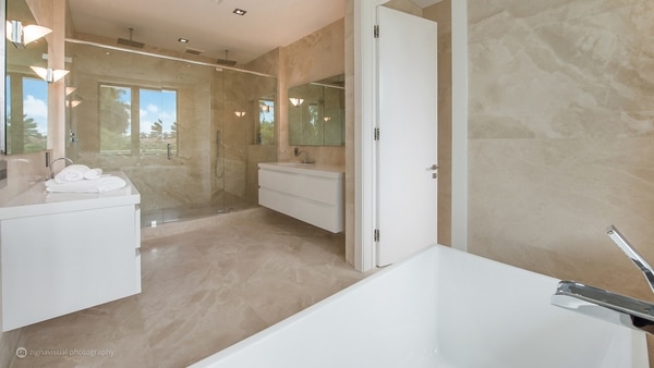 Los cuartos de baño amplios y con mueblería en blanco combinan con el resto de los elementos de la casa