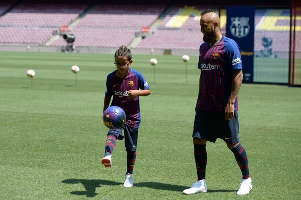 El día de la presentación oficial de Arturo Vidal en Barcelona observa a su hijo Alonso también con la cresta que es característica en la figura chilena / AFP PHOTO / Josep LAGO