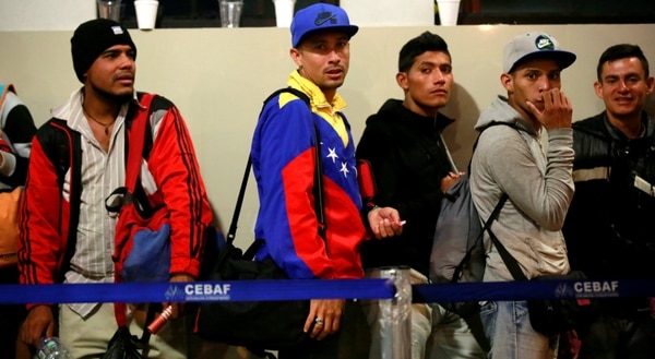 Un grupo de inmigrantes venezolanos espera su turno para presentare antes las autoridades de inmigración peruanas. (Reuters)