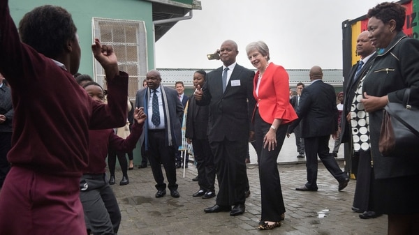 Theresa May posa para una fotografía en una escuela de Sudáfrica (Foto: AFP)
