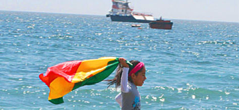 Una niña flamea la tricolor boliviana en la costa del Pacífico.