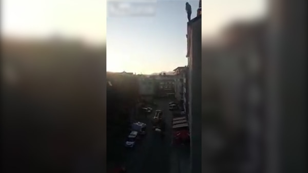 La mujer se paró en la terraza del edificio