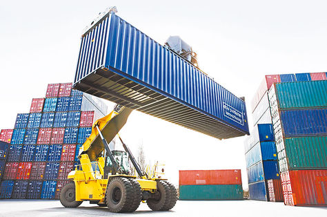 Comercio. Un montacargas para contenedores manipula un vagón con mercadería.
