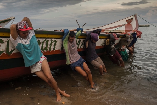 Pescadores venezolanos llegan de pescar durante la noche, donde además de los peligros del mar deben lidiar con los piratas (AP)