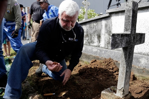 El arqueólogo marítimo James Delgado inspecciona los escombros en la tumba de Julius H. Kroehl antes de exhumar sus restos en el cementerio Amador en el barrio de El Chorrillo, en la ciudad de Panamá (AP Foto/Arnulfo Franco)