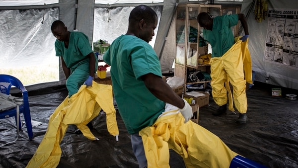 Equipo de trabajadores médicos poniéndose su Equipo de Protección Personal (EPP) antes de ingresar a un centro de tratamiento del ébola (AFP PHOTO / John WESSELS)