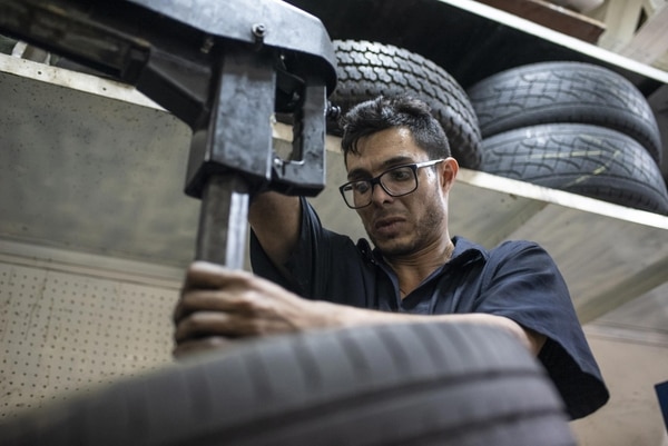 Yhoan Guerrero arreglando un neumático en su taller (Bloomberg/Carlos Becerra)
