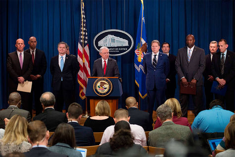 El director del FBI, Christopher Wray, acompañado por funcionarios, incluido el fiscal general Jeff Sessions, habla en una conferencia de prensa sobre la detención de un sospechoso.