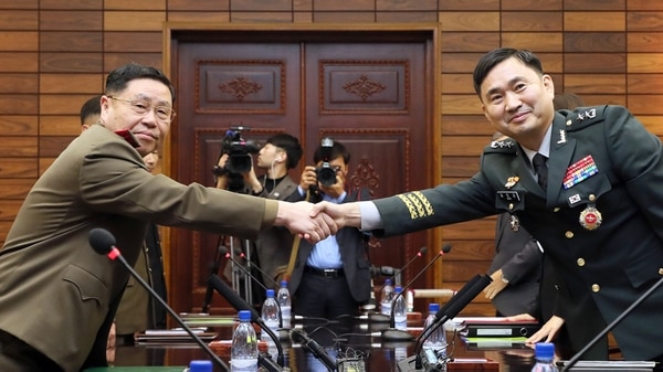 El general Kim do-Gyun (Corea del Sur) estrechando la mano con su homólogo norcoreano Un San durante sus conversaciones militares de nivel general en el lado del norte de la aldea de la tregua de Panmunjom en la zona desmilitarizada (AFP PHOTO / South Korean Defence Ministry)