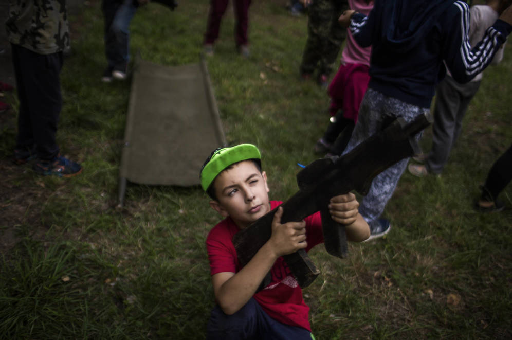 Foto: Un niño posa con una ametralladora de juguete en el campamento Lider. (Foto: Ethel Bonet)