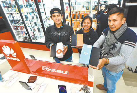 Venta. Jóvenes del local San Miguel, en la Eloy Salmón, muestran las marcas Xiaomi, Samsung y Huawei.