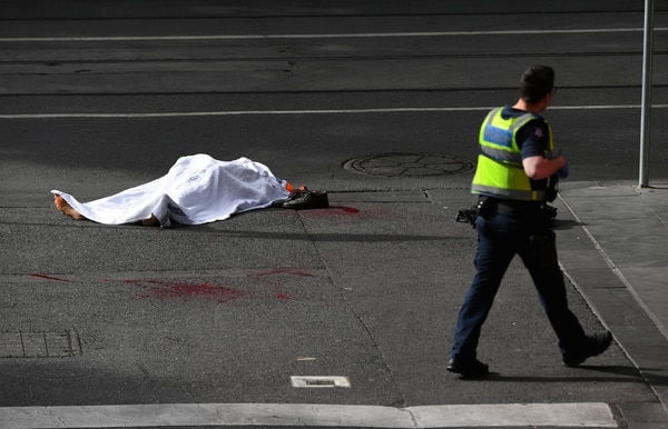 Un policía camina cerca del cuerpo de la víctima mortal del ataque (AAP/James Ross/via REUTERS)