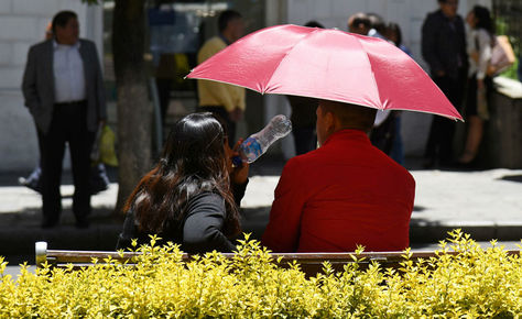 Una pareja en el Prado de La Paz se protege de los rayos solares.