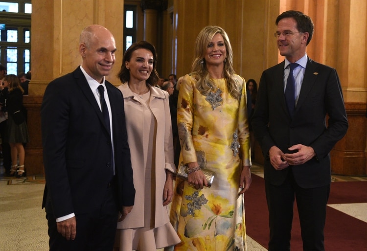 Horacio Rodríguez Larreta y su mujer Bárbara Diez posan en las escalinatas del Colón con la reina Máxima de Holanda y Mark Rutte, Primer ministro de Holanda. La reina de Holanda lució un vestido midi en amarillo estampado de seda natural con apliques de cristales y piedras. Completó su look con clutch de brillantes y brazalete plateado.