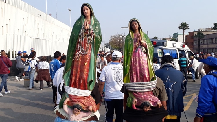 Es común ver que la gente llegue cargando grandes figuras de la virgen en la espalda. (Foto: Juan Vicente Manrique/ Infobae México)