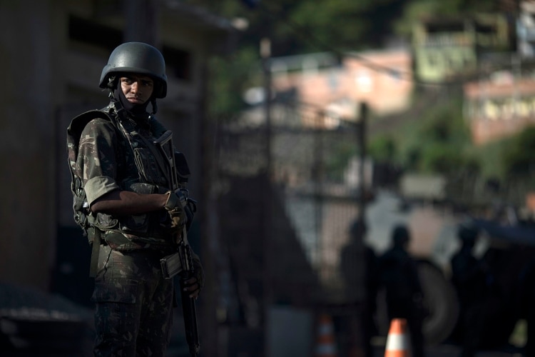 A soldier patrols in the Chapadao complex slum in Rio de Janeiro, Brazil, Tuesday, Dec. 11, 2018. Thousands of soldiers and police are patrolling some favelas, in the suburbs of Rio, as part of security actions to diminish the violence in the state. (AP Photo/Leo Correa)
