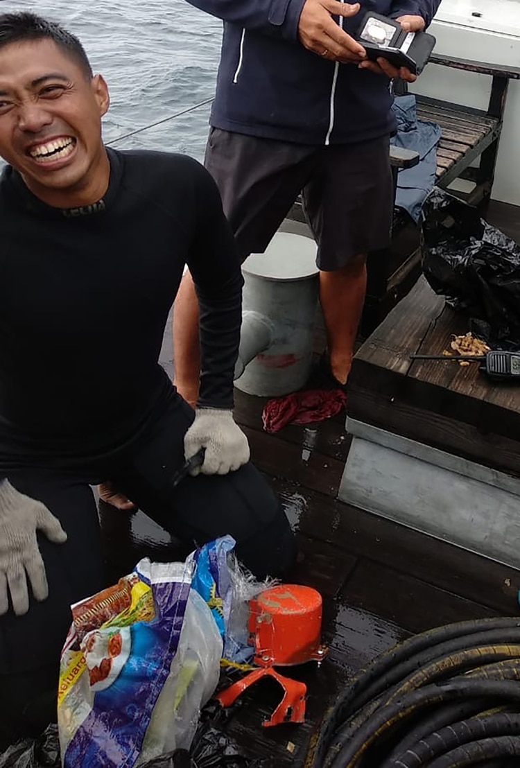 Un buceador con la segunda caja negra del avión (Handout / Indonesian Navy TNI-AL / AFP)