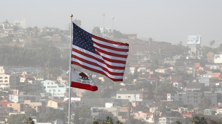 La bandera de Estados Unidos y la de California en la frontera con México. (REUTERS/Mike Blake)