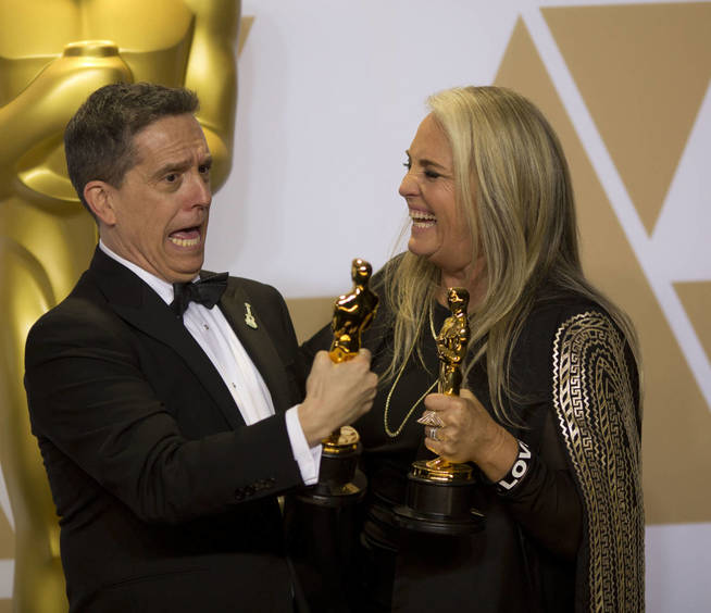 El director Lee Unkrich y la productora Darla K. Anderson posan con su premio a Mejor pelÃ­cula animada por la pelÃ­cula 