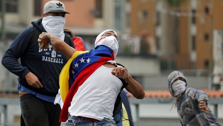Un manifestante se enfrenta a la policía chavista (Reuters)