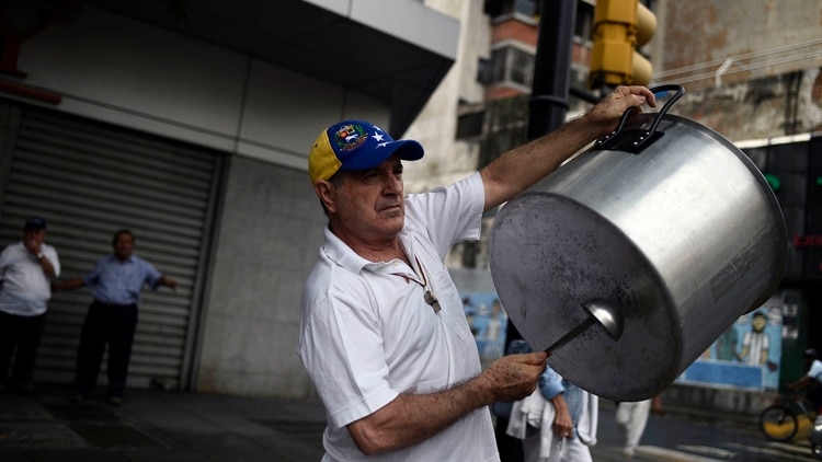 Un hombre hace un cacerolazo (AFP)