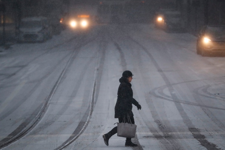 Una mujer cruza una calle en medio de temperaturas gélidas, el miércoles 30 de enero de 2019 en Cincinnati. (AP Foto/John Minchillo)