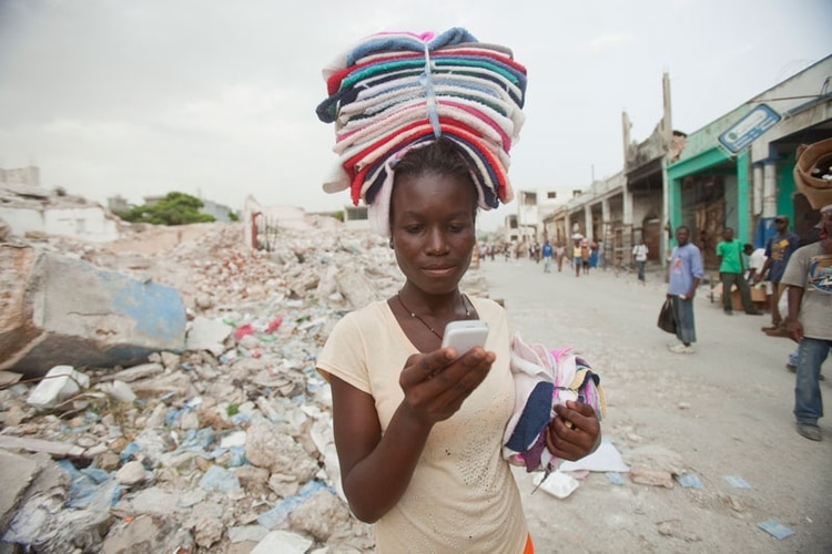 A mujeres como Ketteline Pierre, estudiante secundaria y trabajadora en Haiti, el teléfono celular les abre posibilidades que de otra forma no tendrían. (Bill and Melinda Gates Foundation)