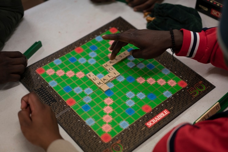 Migrantes juegan Scrabble. (Samuel Aranda/The New York Times)