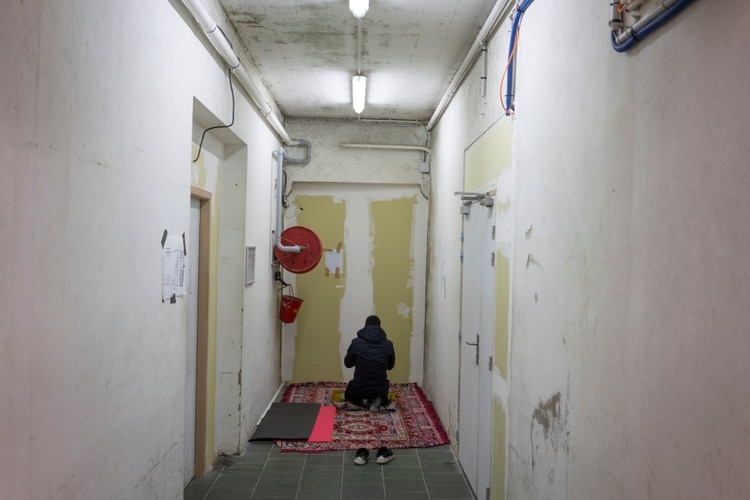 Un migrante reza a la mañana en un albergue. (Samuel Aranda/The New York Times)
