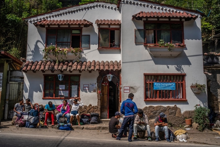 Migrantes afuera de un albergue improvisado en Pamplona, donde la mayoría de las noches se hospedan unas sesenta personas. (Federico Ríos Escobar / The New York Times)