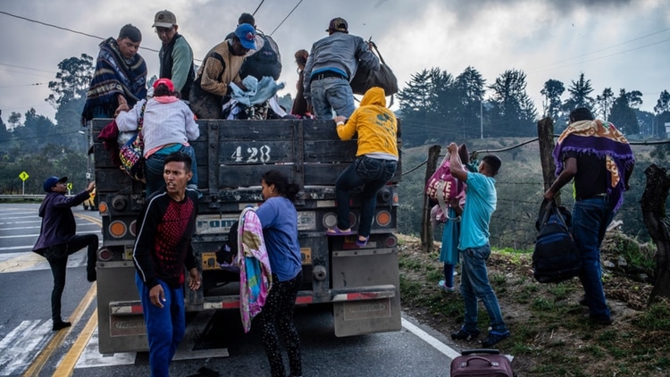 Un grupo de migrantes venezolanos que avanzaban a pie se preparan para subir a un camión que se detuvo para llevarlos. (Federico Ríos Escobar / The New York Times)