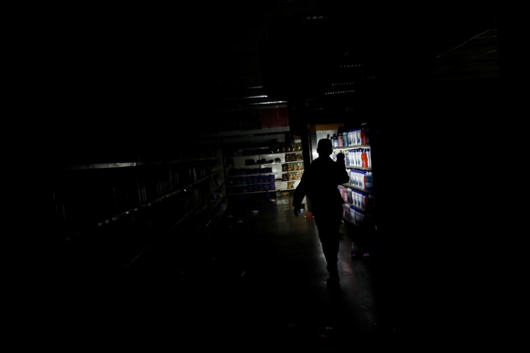 Un empleado inspecciona los daños en un supermercado de la capital