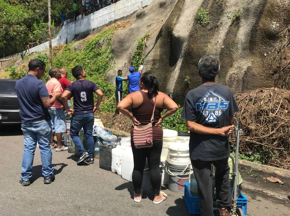 Grupos de personas esperan para recoger agua de los manantiales del Ãvila. (A. HernÃ¡ndez)