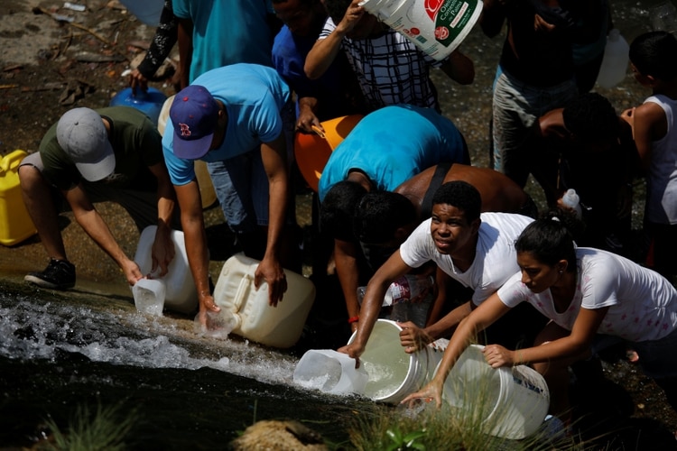 Habitantes de Caracas tratan de conseguir agua en el río Guaire (REUTERS/Carlos Garcia Rawlins)