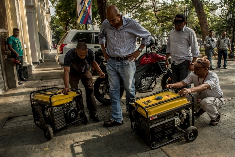 Trabajadores gubernamentales intentaban encender los generadores eléctricos en el centro de Caracas. Mucha gente no tenía combustible para sus generadores. (Credit Meridith Kohut para The New York Times)