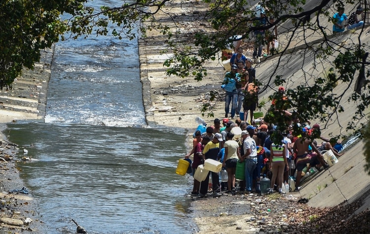 Algunas familias llegaron a un desagüe del río Guaire en Caracas (AFP)