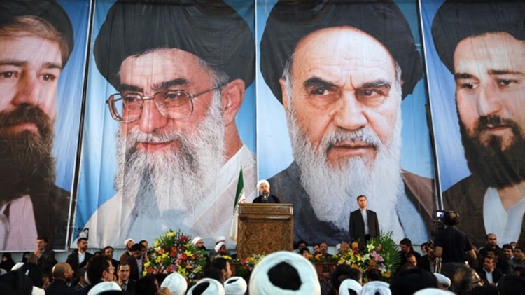 El presidente iraní Hasan Rohani con la imagen de los líderes supremos de fondo (AFP)
