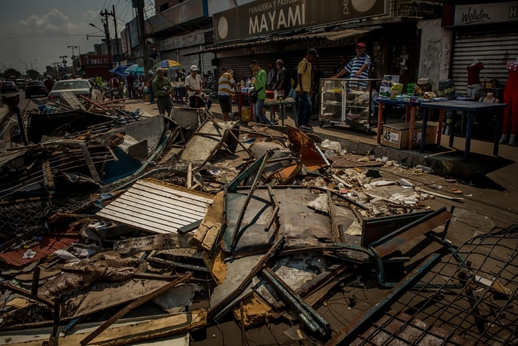 Los escombros de las tiendas que fueron saqueadas llenaban una calle de Maracaibo. (Meridith Kohut para The New York Times)