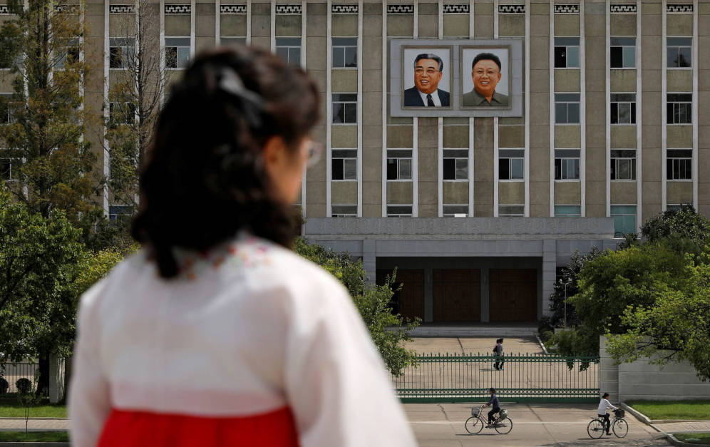 Foto: Una mujer frente a los retratos de los fallecidos lÃ­deres norcoreanos Kim Il-sung y Kim Jong-il en una fachada en Pyongyang, en septiembre de 2018. (Reuters)