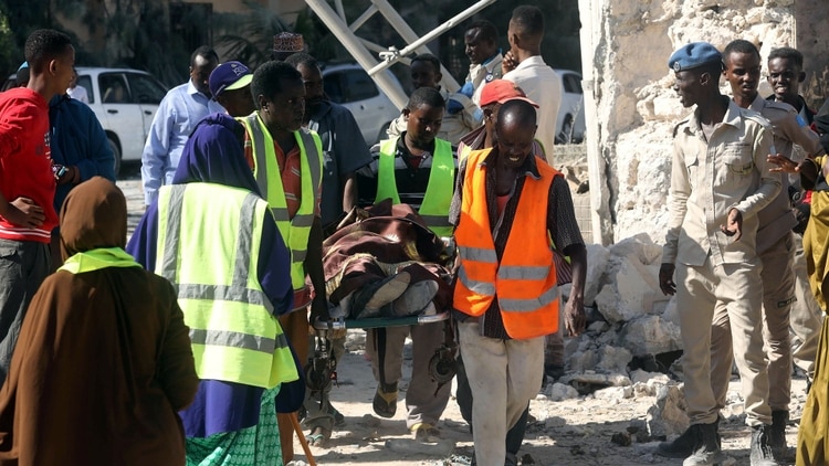 Civiles transportan el cuerpo sin vida de un trabajador asesinado en la toma de un edificio por parte de Al Shabab (REUTERS/Feisal Omar)