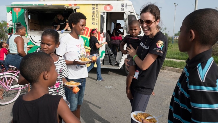 Una de los principales asistentes de José Andrés en World Central Kitchen, Erin Schrode (quien sostiene a un niño) todavía está en la isla.Érika P. Rodríguez para The New York Times