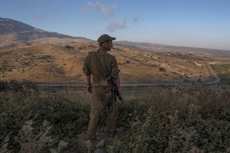Un soldado israelí mira hacia Siria desde los altos del Golán, un área estratégica que le da una ventaja militar en la región a quien la controle. (Uriel Sinai para The New York Times)
